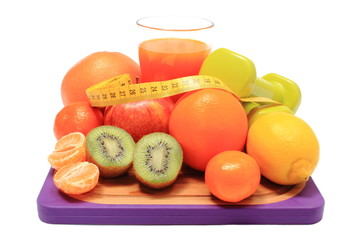 Fresh fruits, dumbbells, tape measure and glass of juice