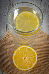 Fresh lemon and glass of clean water with slice of lemon, cold lemonade