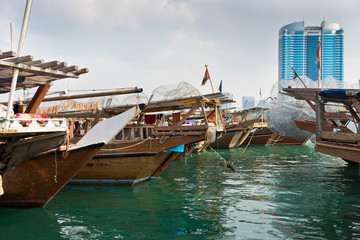 Fototapeta na wymiar Abu Dhabi buildings skyline with old fishing boats