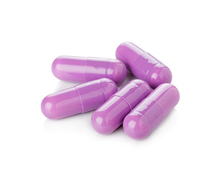Purple pill capsules on white background