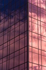 Sky and clouds reflected in windows of office building