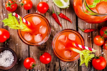 tomato juice with celery and ice in glasses
