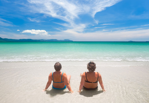 Two Mature Woman In Swimwear  Relaxing On The Beach