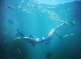 Underwater shot of the woman moving on the breath hold in the depth