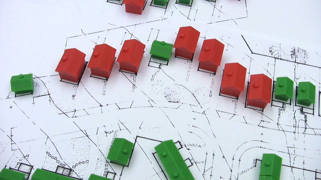 Red and green model houses on a real estate housing development plan. 