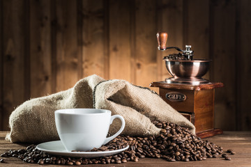 still life with coffee beans and old coffee mill on the wooden background