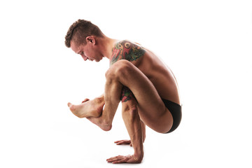 young strong man doing yoga and gymnastics, yoga asana