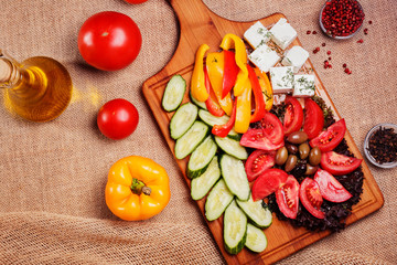 Rustic fresh Vegetables with Feta and olives on rustic wooden bo