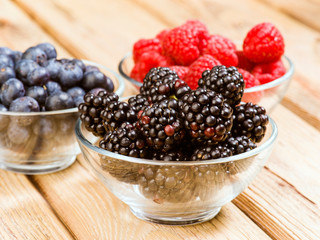 blueberries blackberries and raspberries in glass bowl