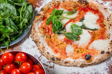 Traditional italian pizza with mozzarella, tomato and basil, on