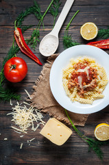 Italian meat sauce pasta and fresh delicious ingredients for cooking on rustic background
