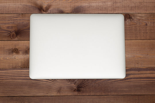 Closed Silver Laptop On Brown Wooden Table