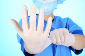Arzt in OP-Kleidung zieht Einweg-Handschuhe an