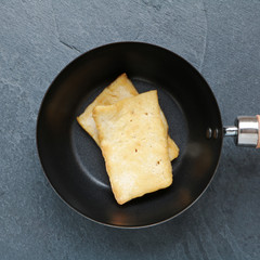 Tofu frit dans une poêle sur ardoise