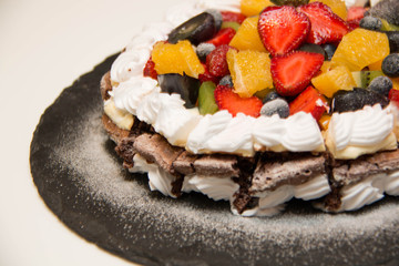  Shot chocolate cake topped with fresh fruit.