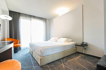 Interior of a double hotel bedroom in the morning, sunlight