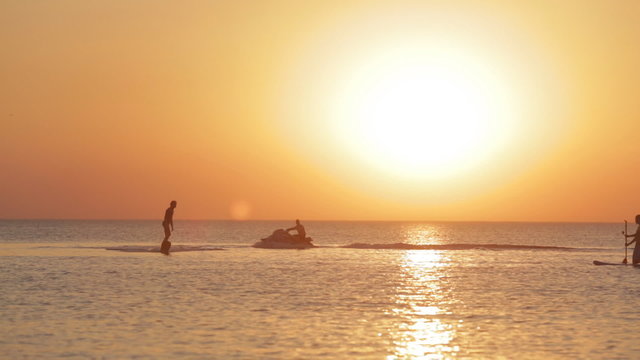 Silhouette of a Man Having Fun on Flyboard in the Sea at Sunset Background