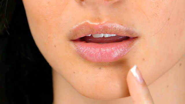 Woman's tongue seductively licking lips, close up,slow motion 