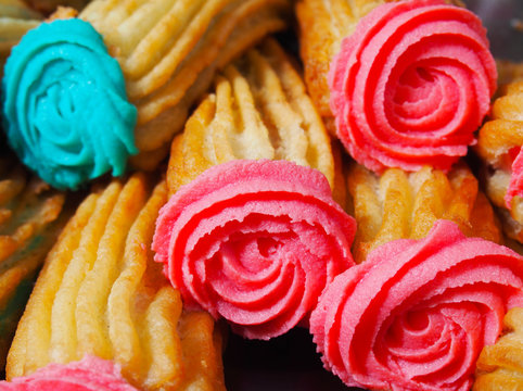 Spanish traditional fried-dough pastry porras with colorful glaze tops