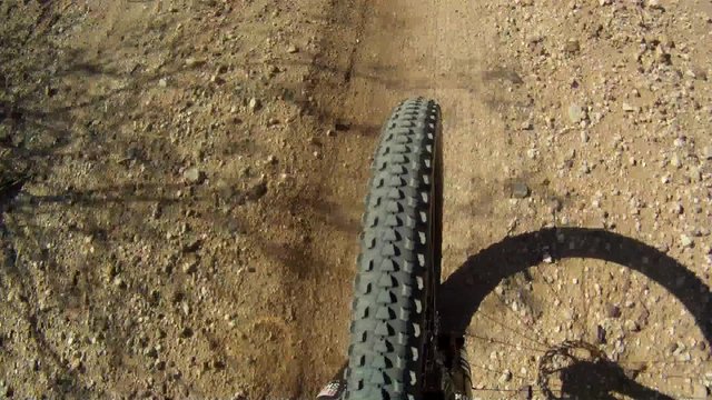 Mountain biking POV of front tire on a trail