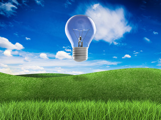 think green concept with green field, blue sky and idea lightbulb