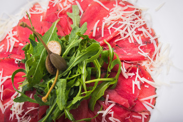 white dish with carpaccio and cheese