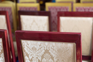 beige cushion with flower pattern decorating with wooden chair