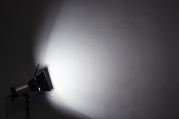 Fototapeta na wymiar Lighting equipment on a black background old shabby wall