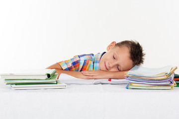 Tired school boy is sleeping on desk