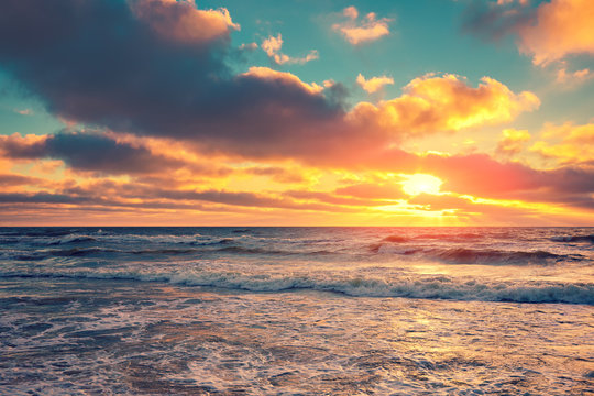 Sea shore at sunset with cloudy sky