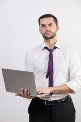 Young business man with a laptop in a studio