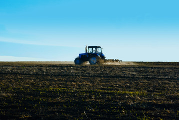 Tractor plows a field in the spring before sowing campaign