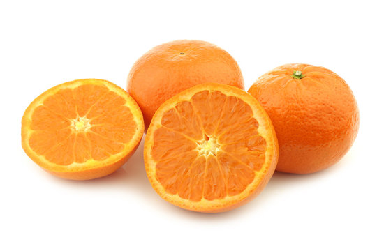 fresh tangerines and a cut one on a white background
