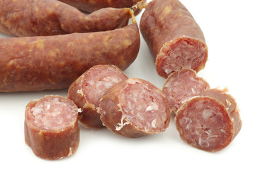 cut pieces of traditional frisian smoked and dried sausages on a white background
