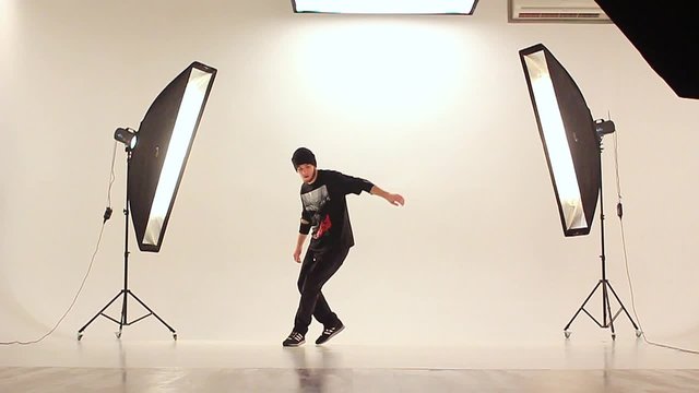 B-boy dancing breakdance in a photo studio on a white background.