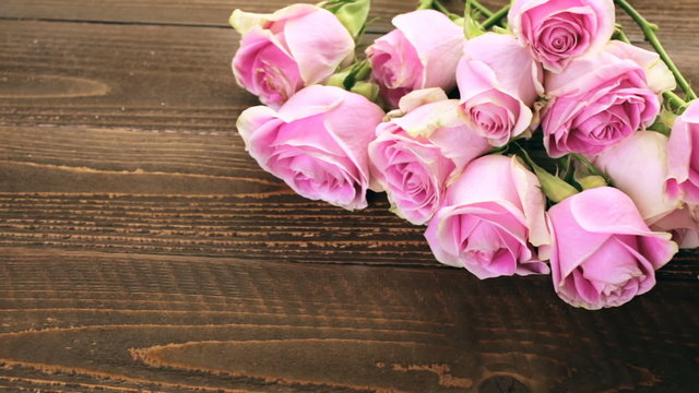 Pink roses on rustic wood table