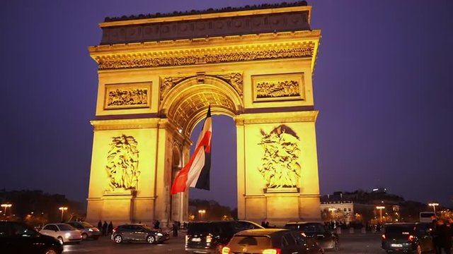Triumphs arch called Arc de Triomphe with French flag in the evening