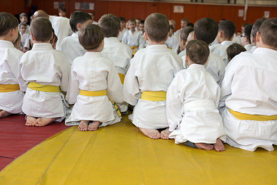 Children in kimono sitting on tatami on martial arts seminar. Selective focus