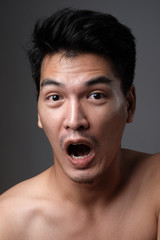 Asian man portrait with no makeup show his real skin in grey background - soft focus