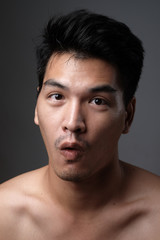 Fototapeta premium Asian man portrait with no makeup show his real skin in grey background - soft focus