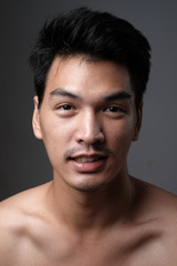 Fototapeta premium Asian man portrait with no makeup show his real skin in grey background - soft focus