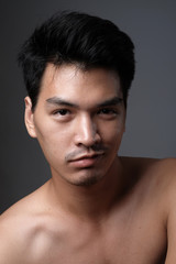 Asian man portrait with no makeup show his real skin in grey background - soft focus