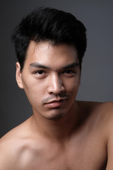 Fototapeta premium Asian man portrait with no makeup show his real skin in grey background - soft focus