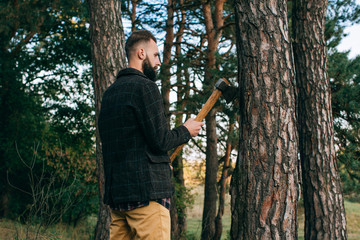 Obraz premium Portrait brutal bearded and moustached woodcutter hipster Gypsy man in the forest with ax