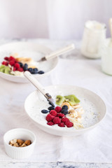 Acai coconut chia bowl with blueberry, raspberries and banana sliced over white linen napkin.