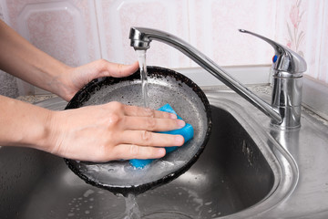 hands washing a pan, closeup