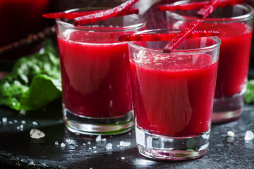 Beetroot juice in glasses on a dark background, selective focus