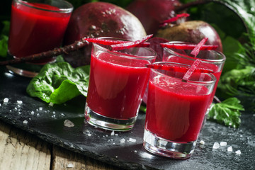 Beetroot juice in glasses on a dark background, selective focus