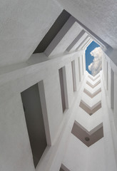 deep atrium gray building overlooking the blue sky with clouds