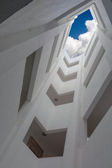 deep atrium gray building overlooking the blue sky with clouds